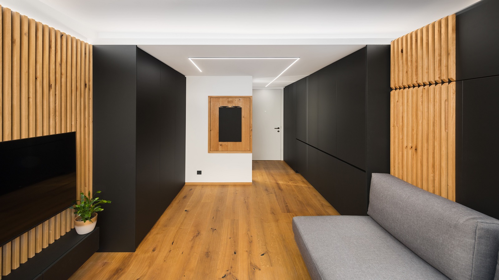 A foldable studio apartment in its folded state, with wooden accents, dark walls and plenty of space