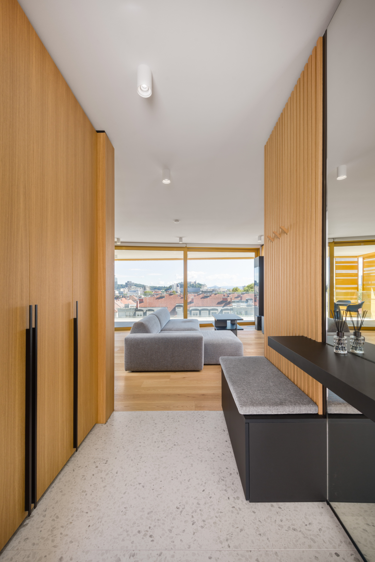Modern design of a hallway in a luxury apartment with wooden cabinets and an upholstered bench