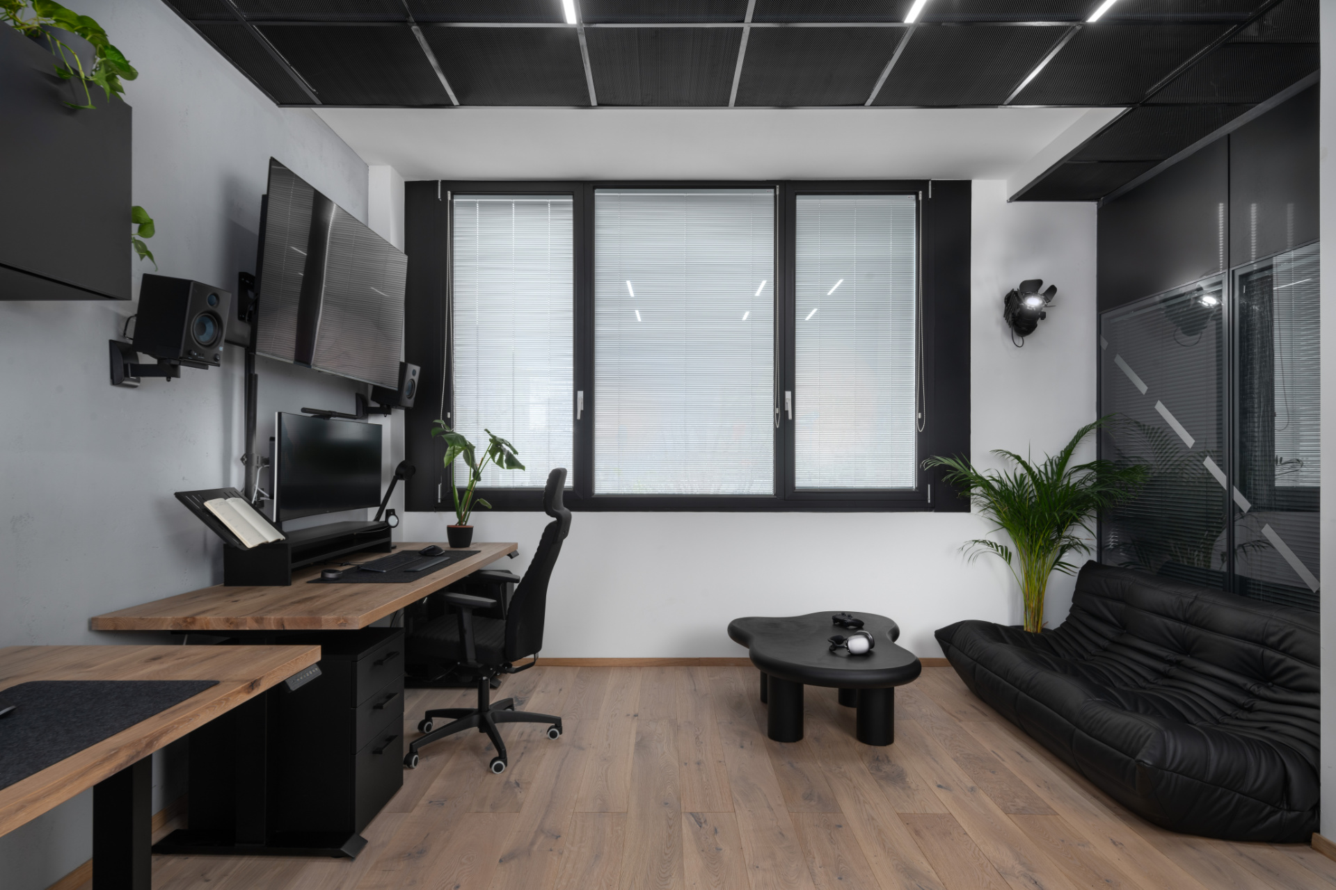 Office in an apartment with a coffee table, black furniture and a black sofa