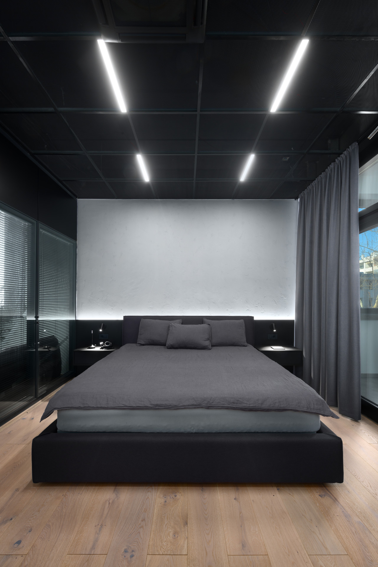 Minimalist black bedroom with illuminated ceiling and bedside tables