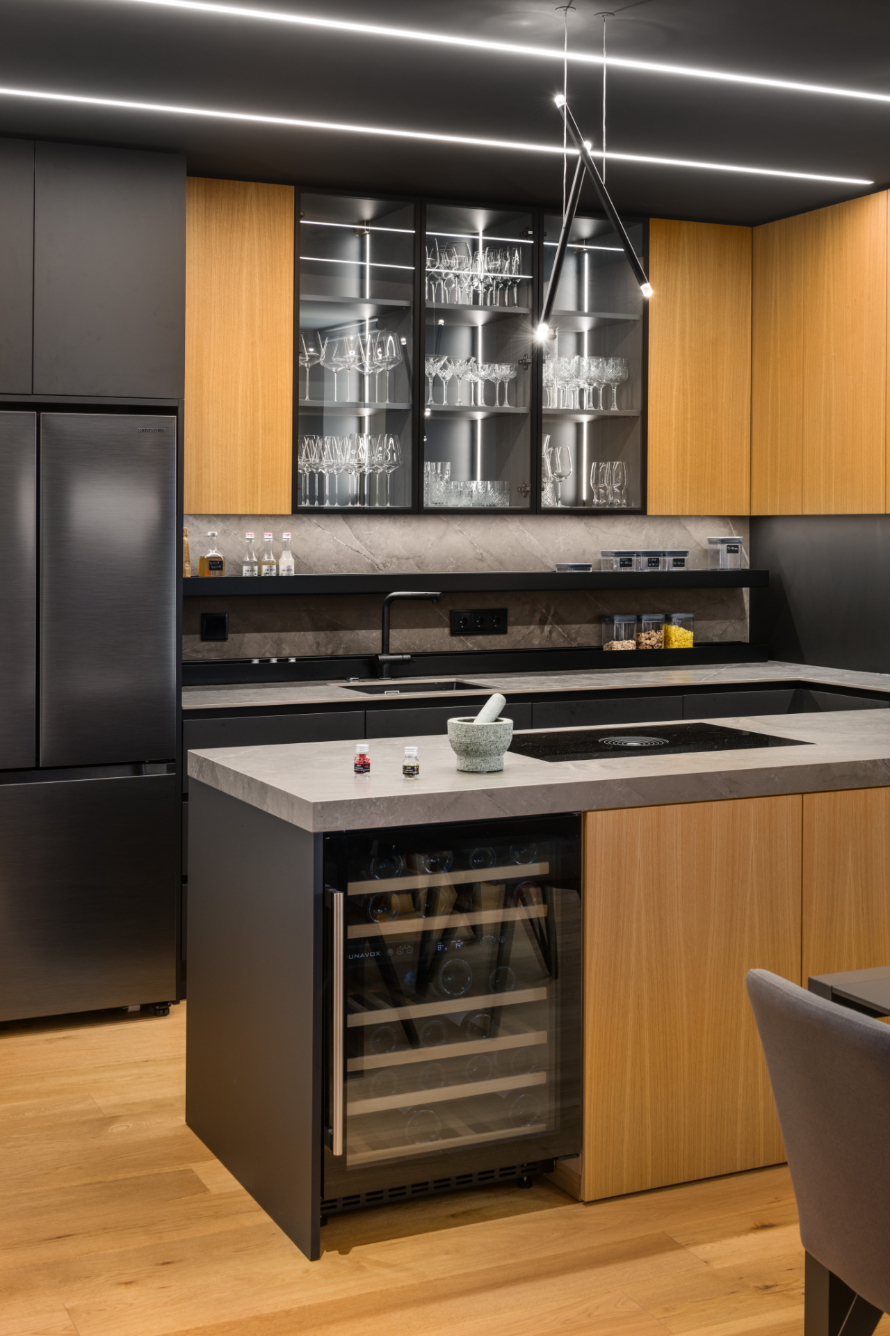 Kitchen in a modern interior with a stone island, a wine fridge and wooden cabinets