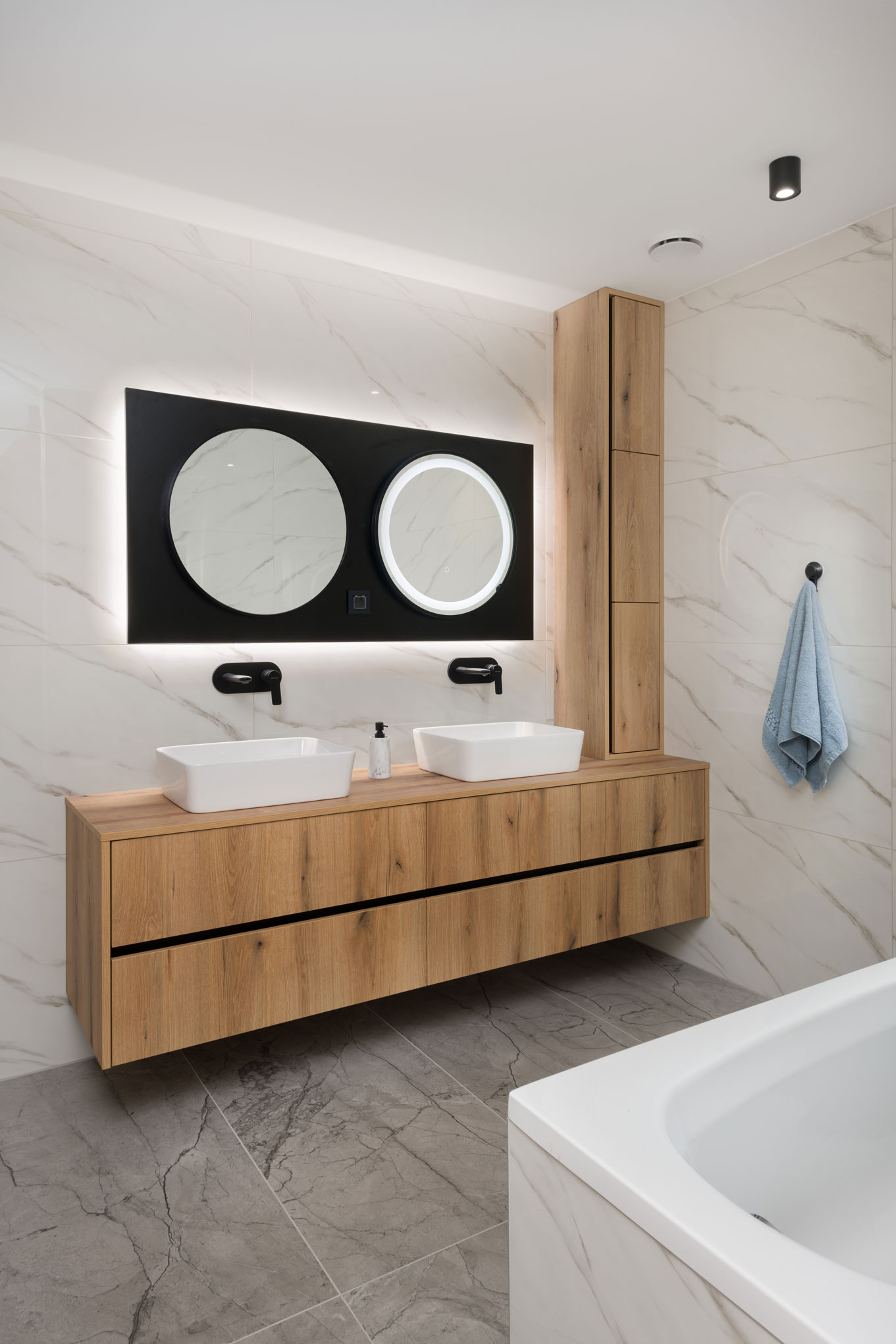 Modern bathroom with double sink, wooden cabinets and mirrors, an example of a modern interior