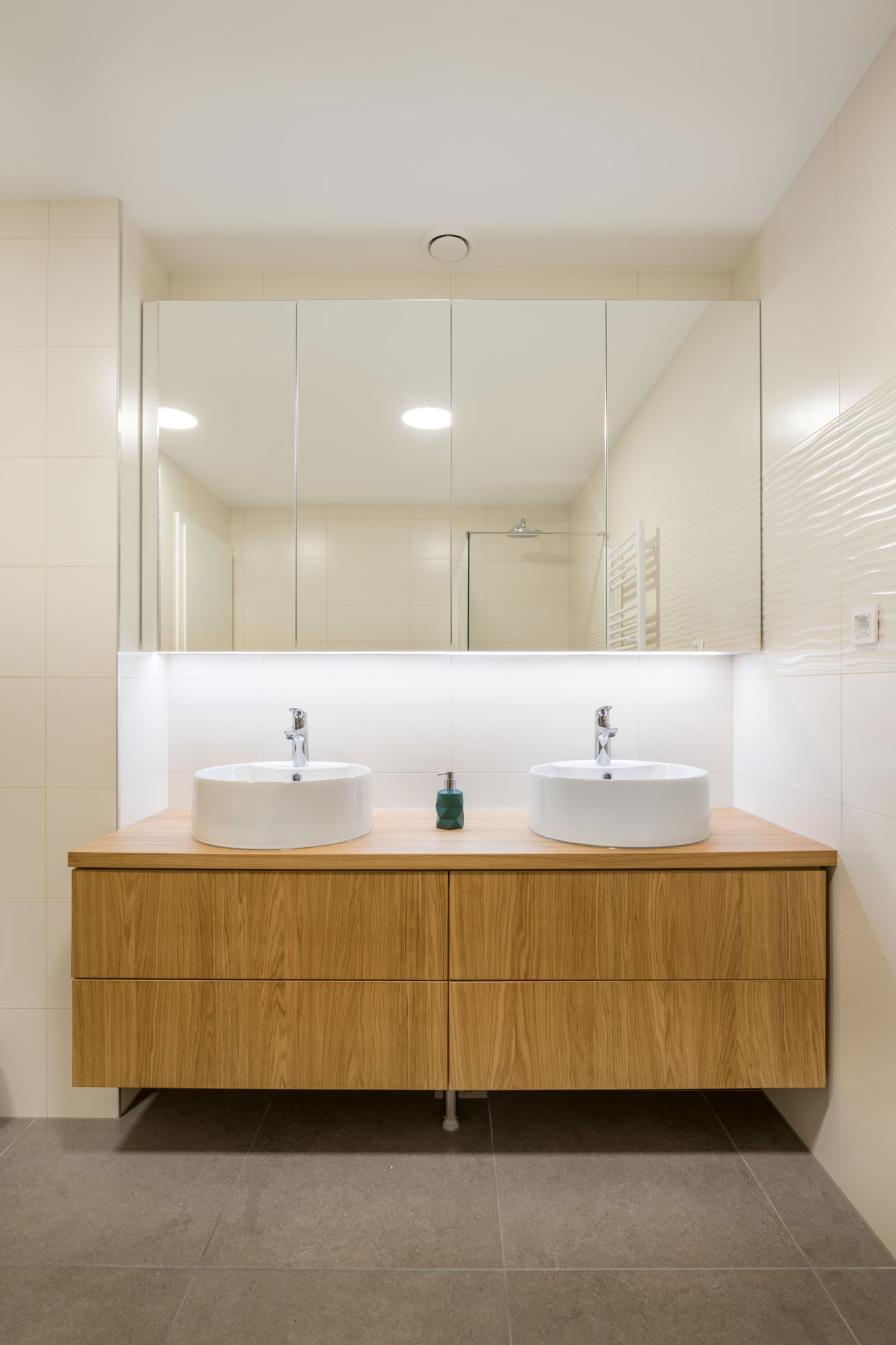 Minimalistična kopalnica z dvojnim nadpultnim umivalnikom, leseno omaro in ogledalom