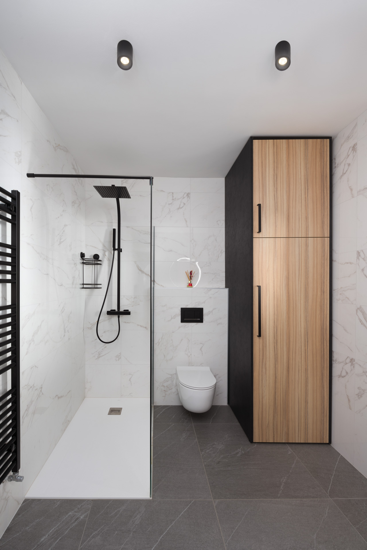 Notranji dizajn svetle kopalnice s tušem in leseno omaro