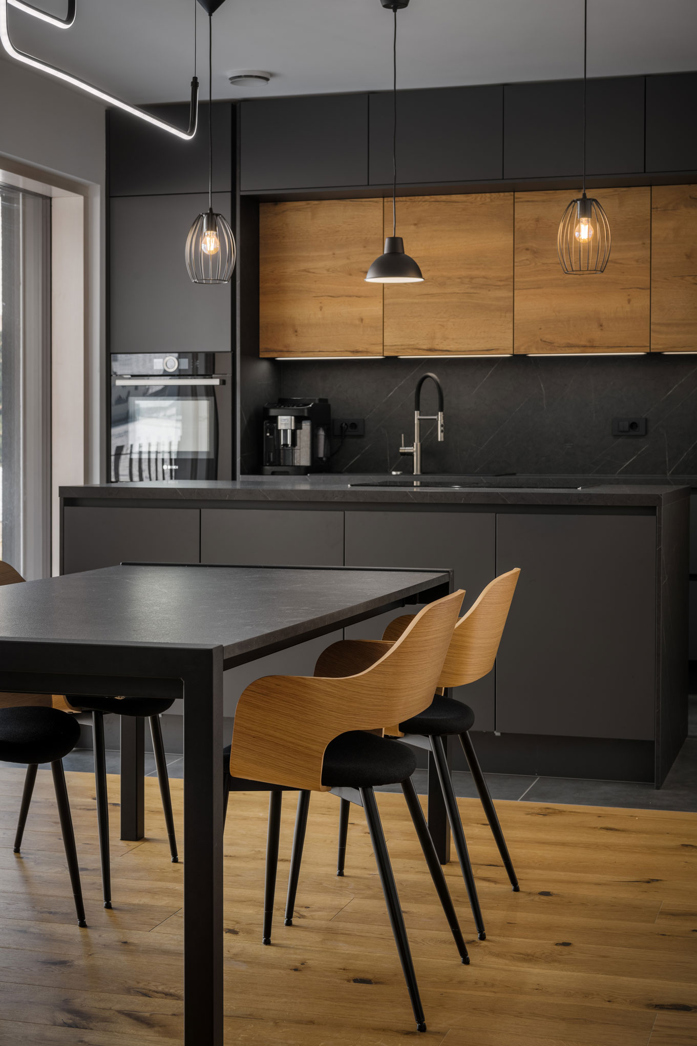 Minimalist kitchen with dining area in a combination of black and wood