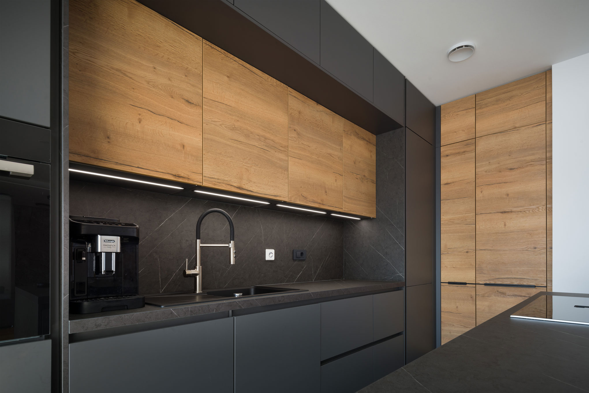 Minimalist kitchen with black and wooden cabinets and modern fixtures, interior design example