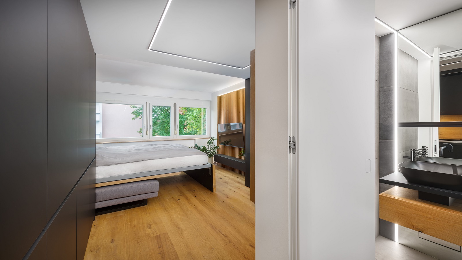 Minimalističen interier dnevne sobe s posteljo in kopalnico