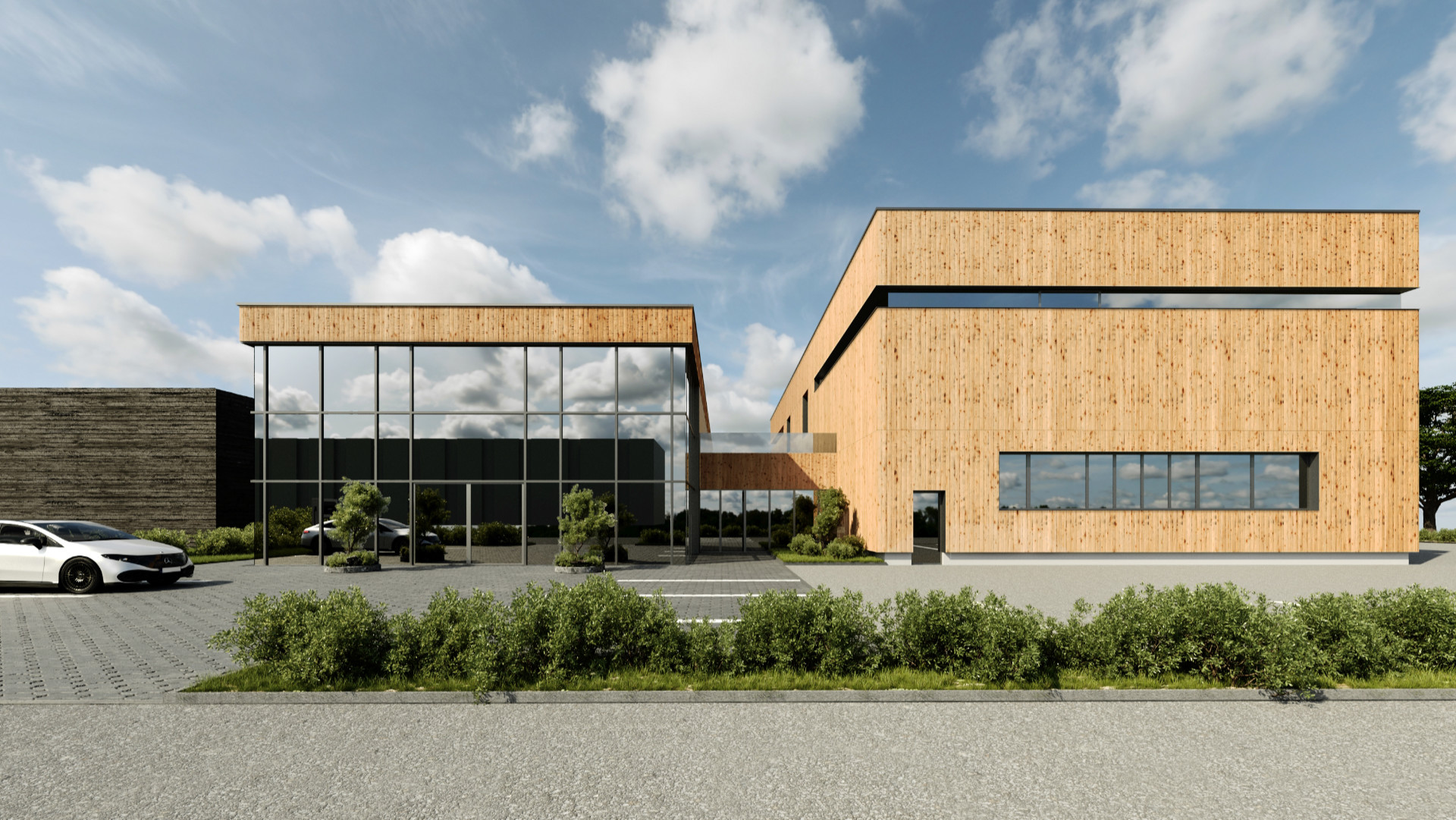 Moderna poslovna stavba v Celovcu z leseno fasado, zelenimi površinami in velikimi okni