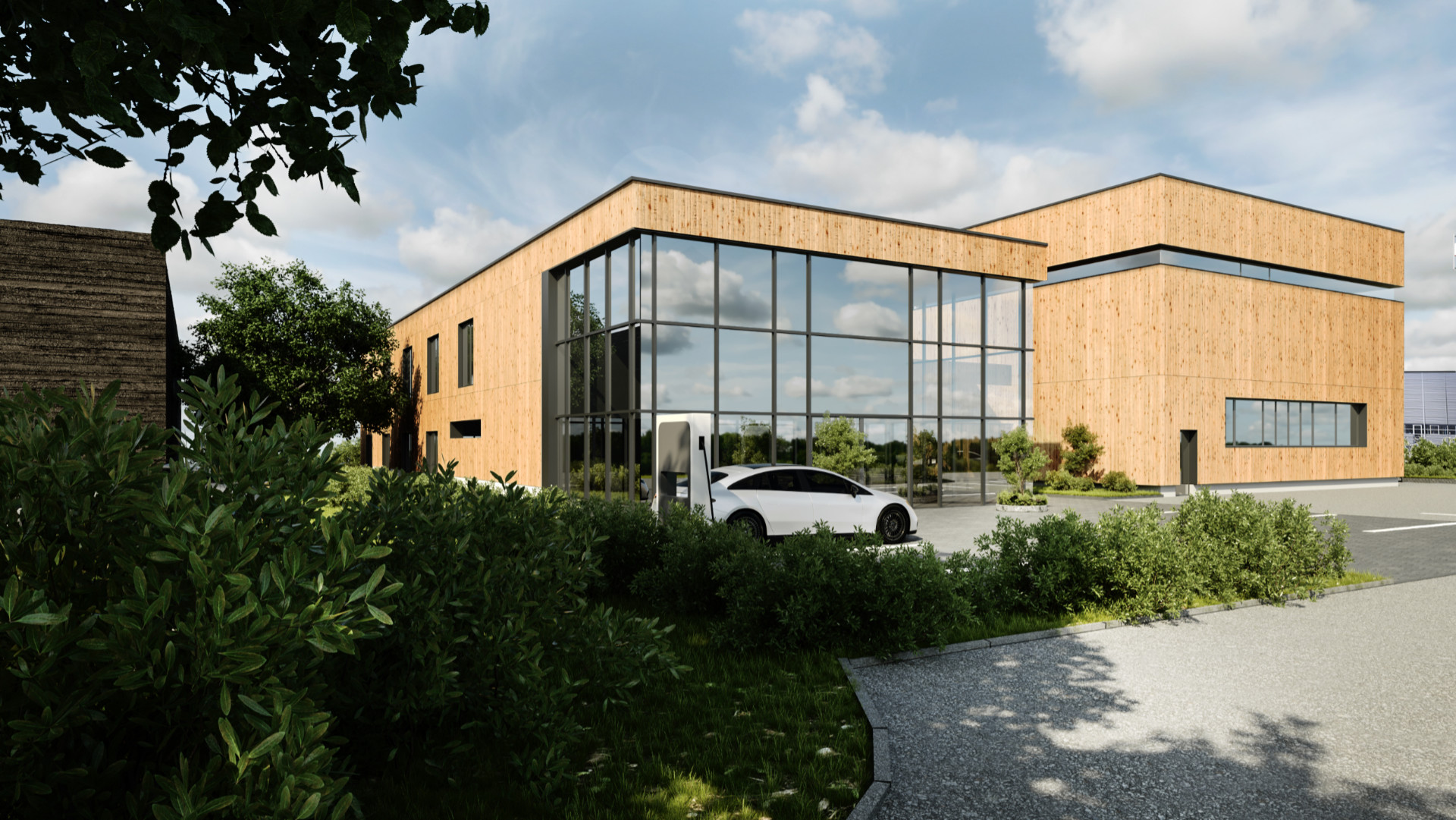 Lesena fasada poslovne stavbe z velikimi okni, prostornim parkiriščem, veliko zelenih rastlin in polnilnico za elektronska vozila