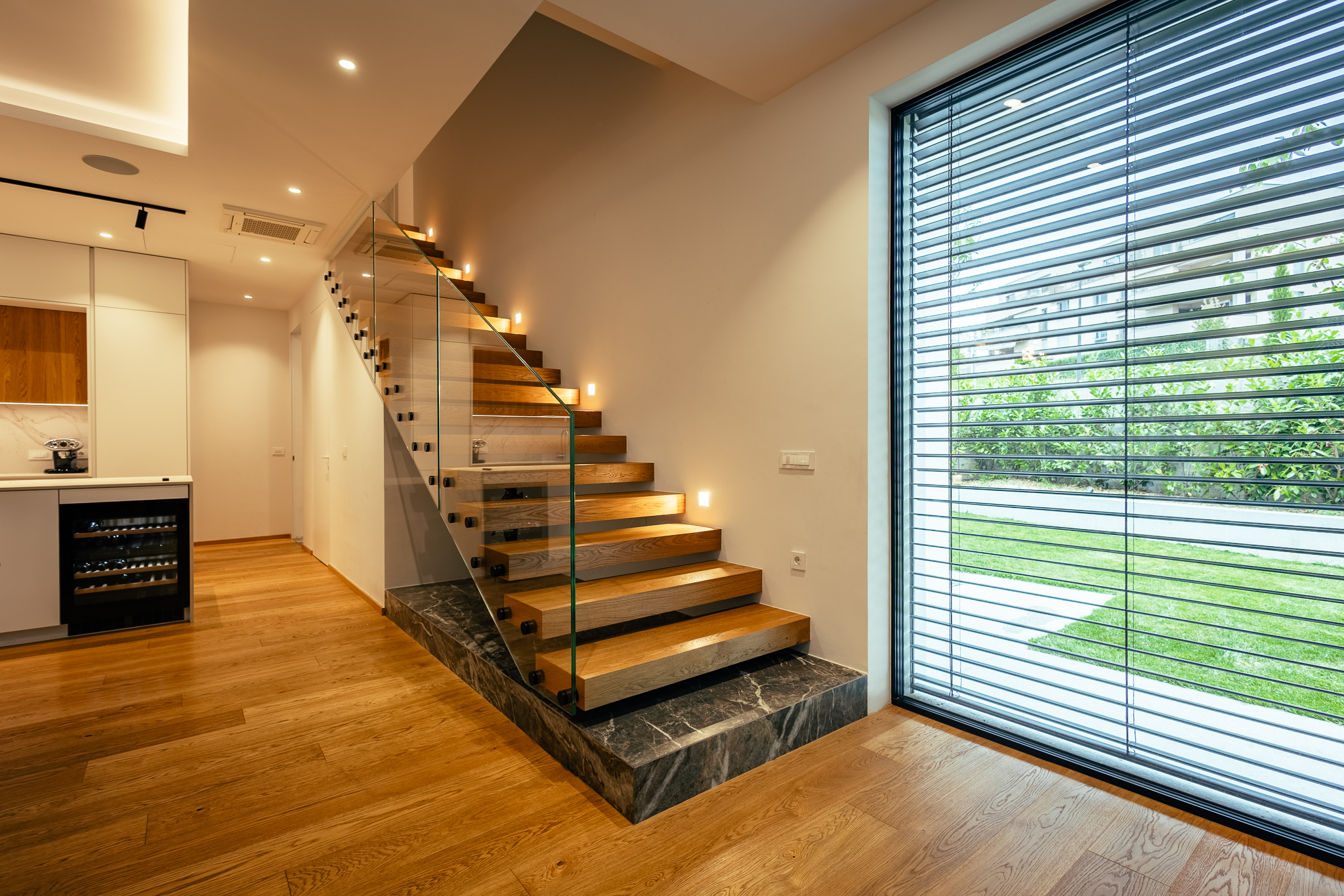 Leseno stopnišče s stekleno ograjo v dnevni sobi luskuzne vile